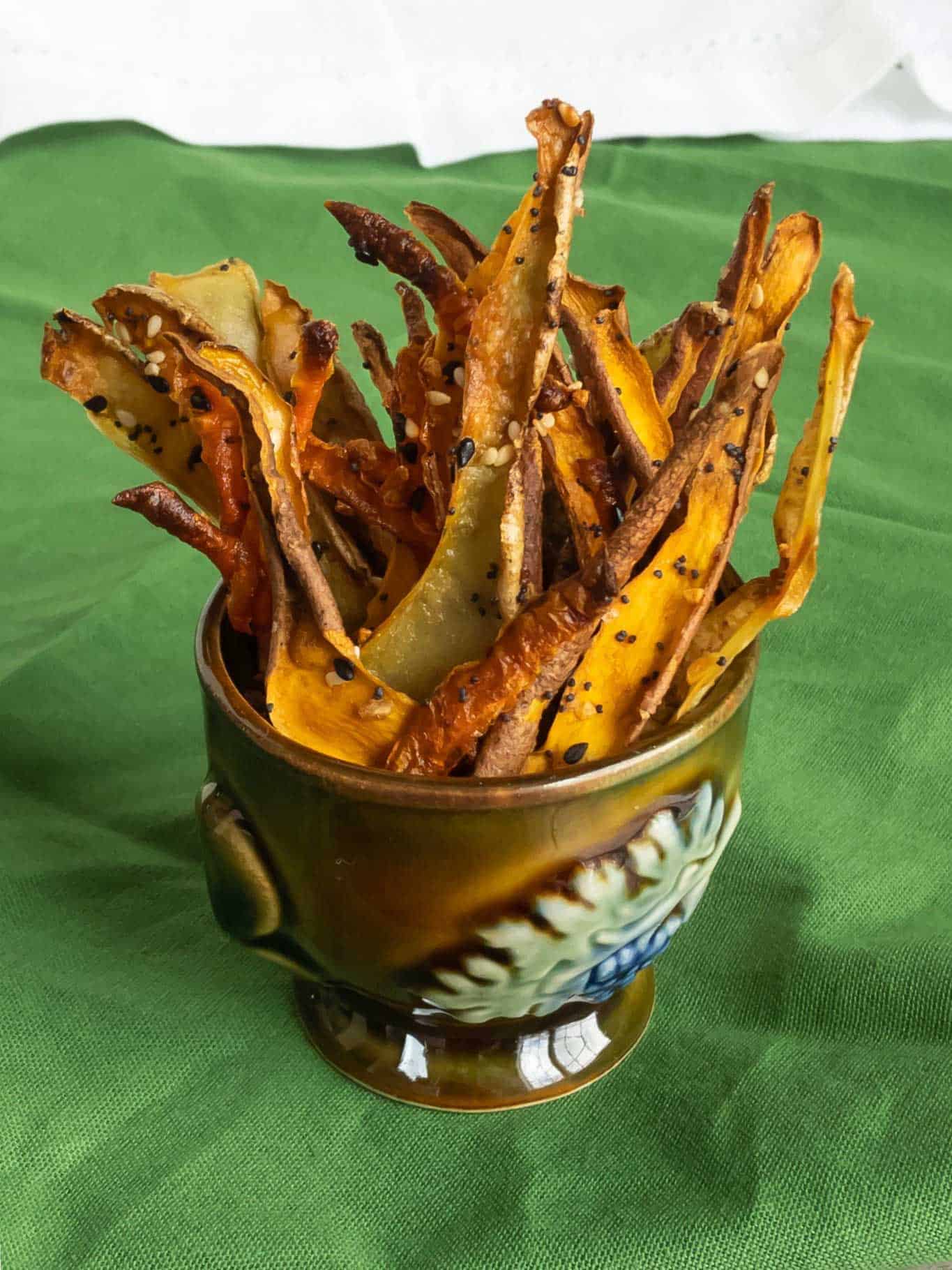 Vegetable skin crisps standing upright in a small cup