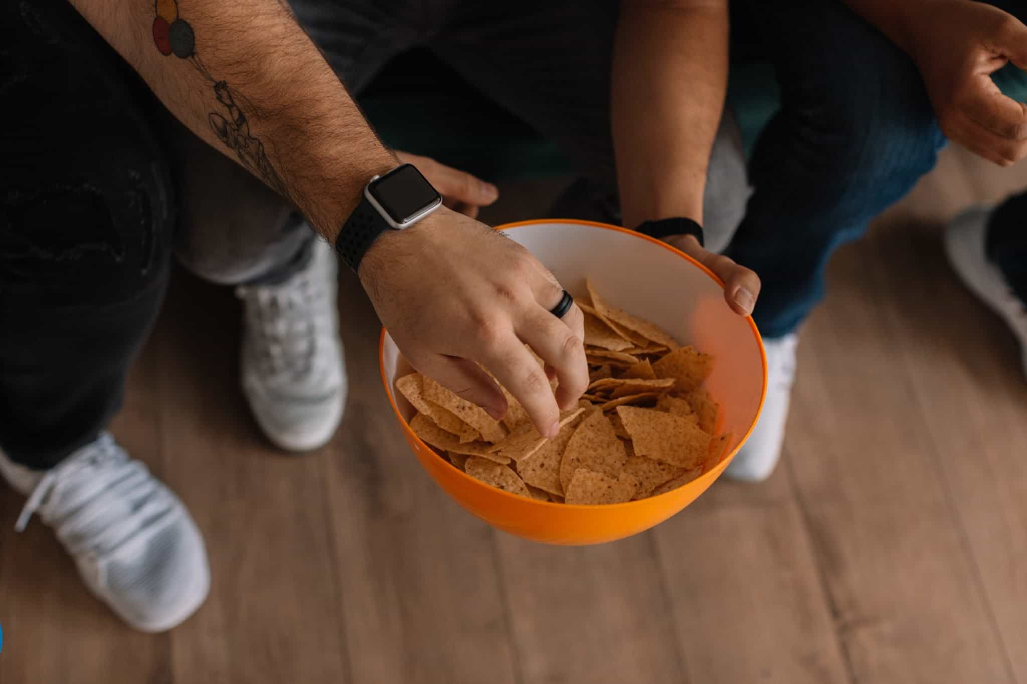 Snacking on chips from a bowl.