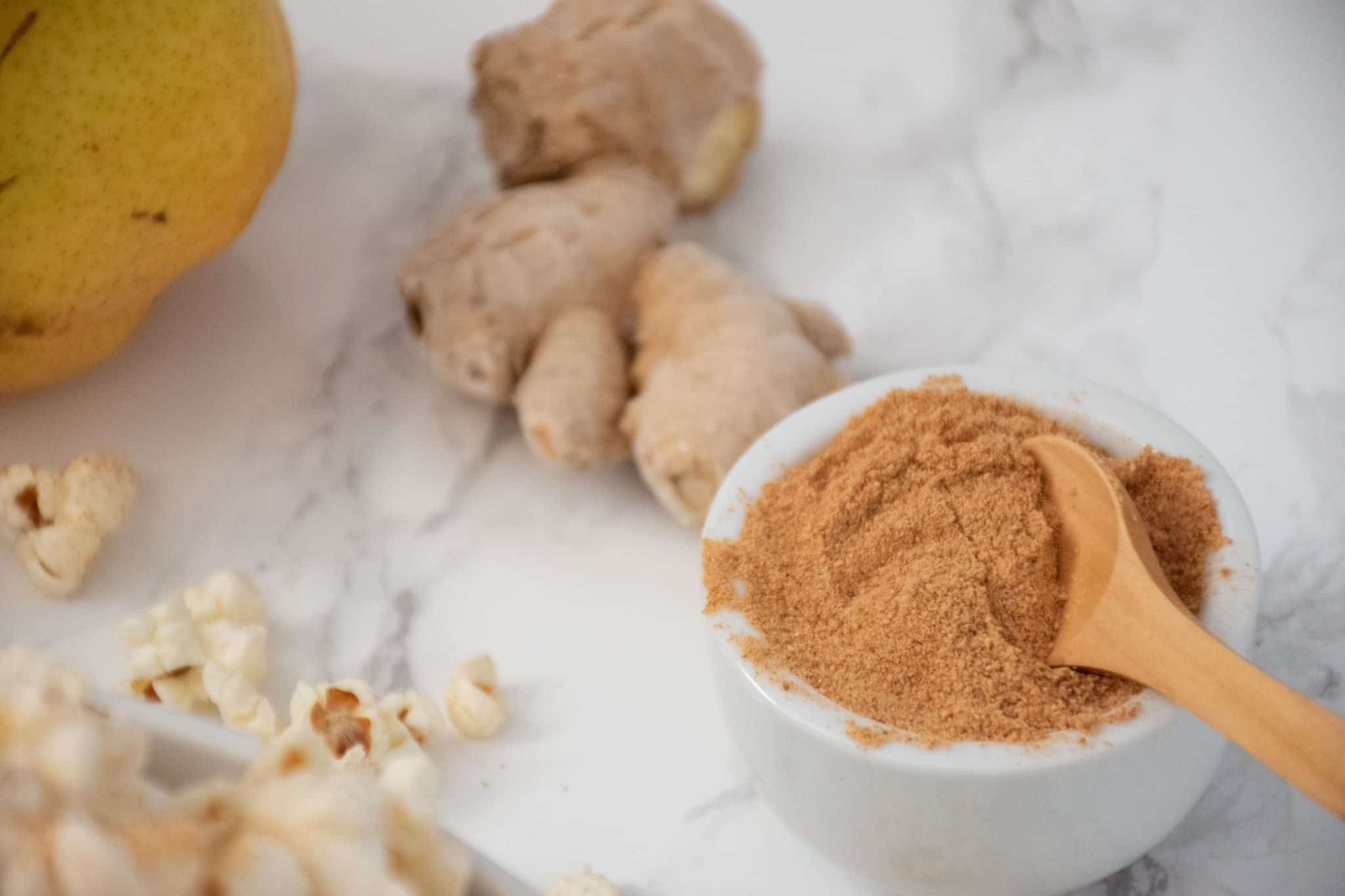 Gingered Pear Seasoning in a small bowl with ginger root and a pear in the background