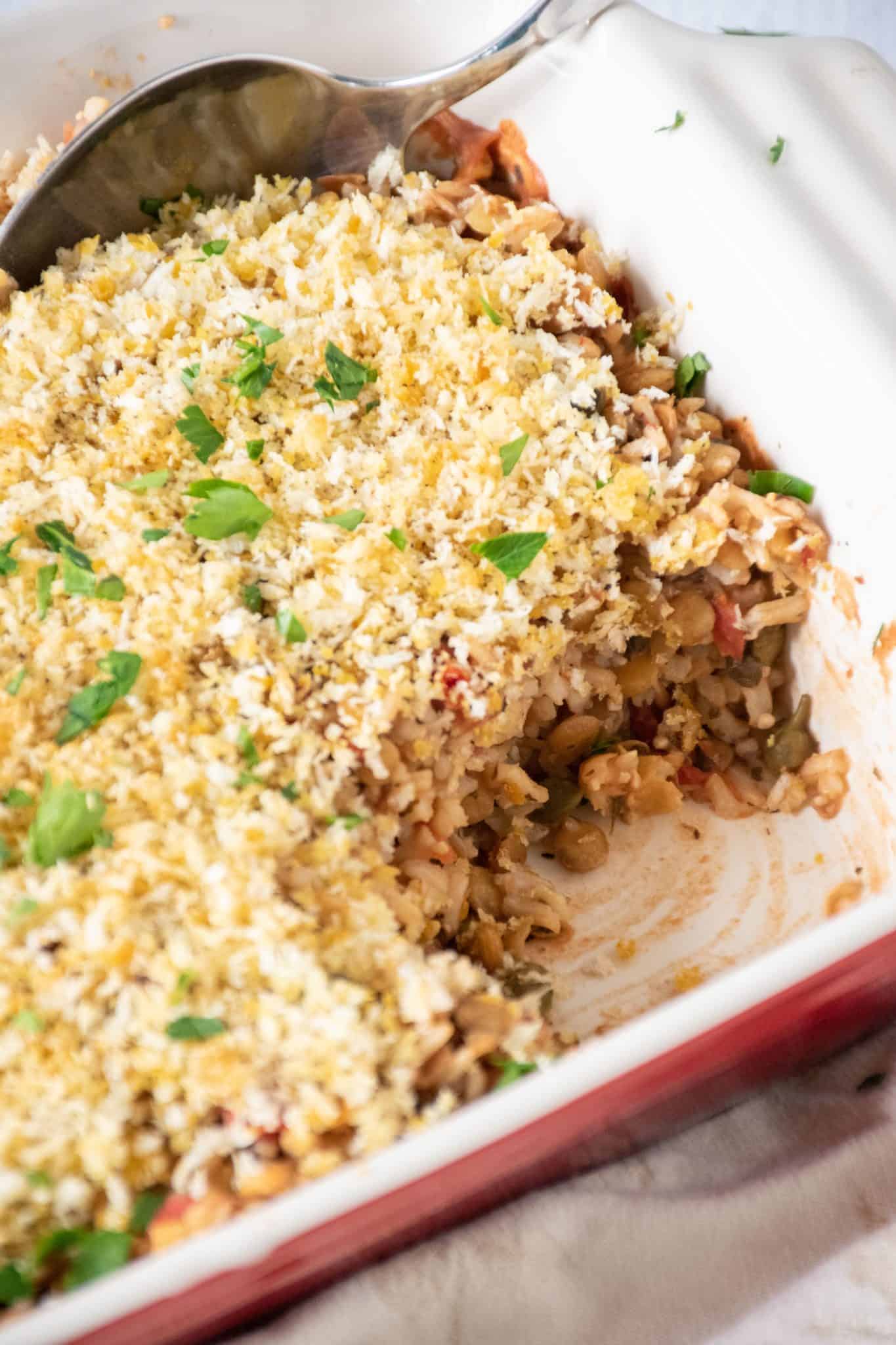 Italian Lentil & Rice casserole in a casserole dish with a scoop removed.