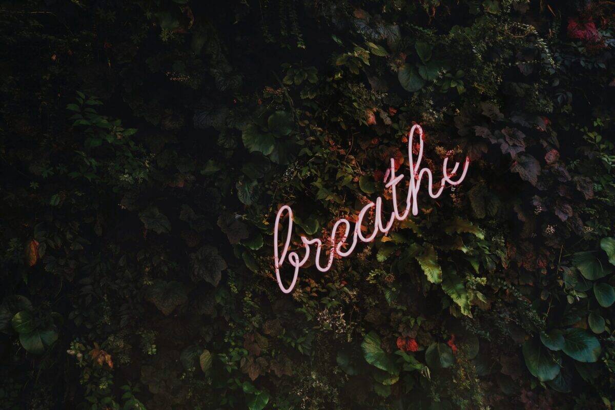 neon light with the word "breathe"