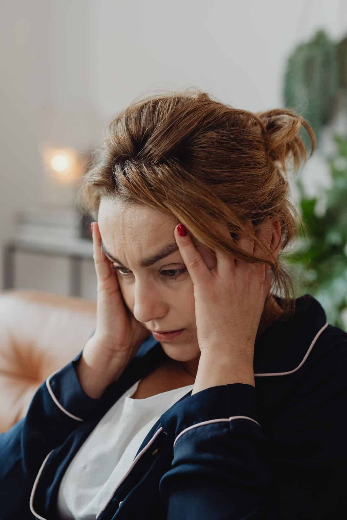 woman with her hands on both sides of her head.