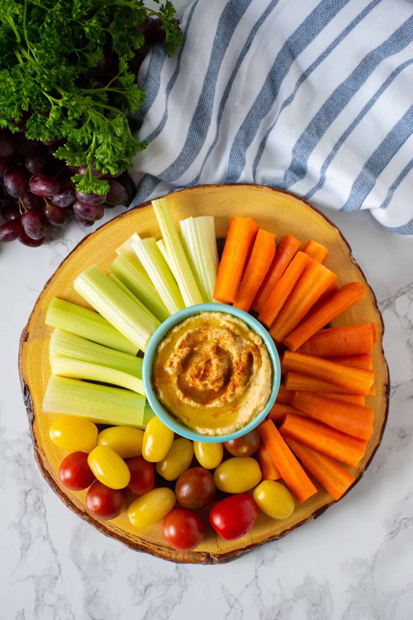 Overhead shot of vegetable platter with a bowl of pantry basics hummus.