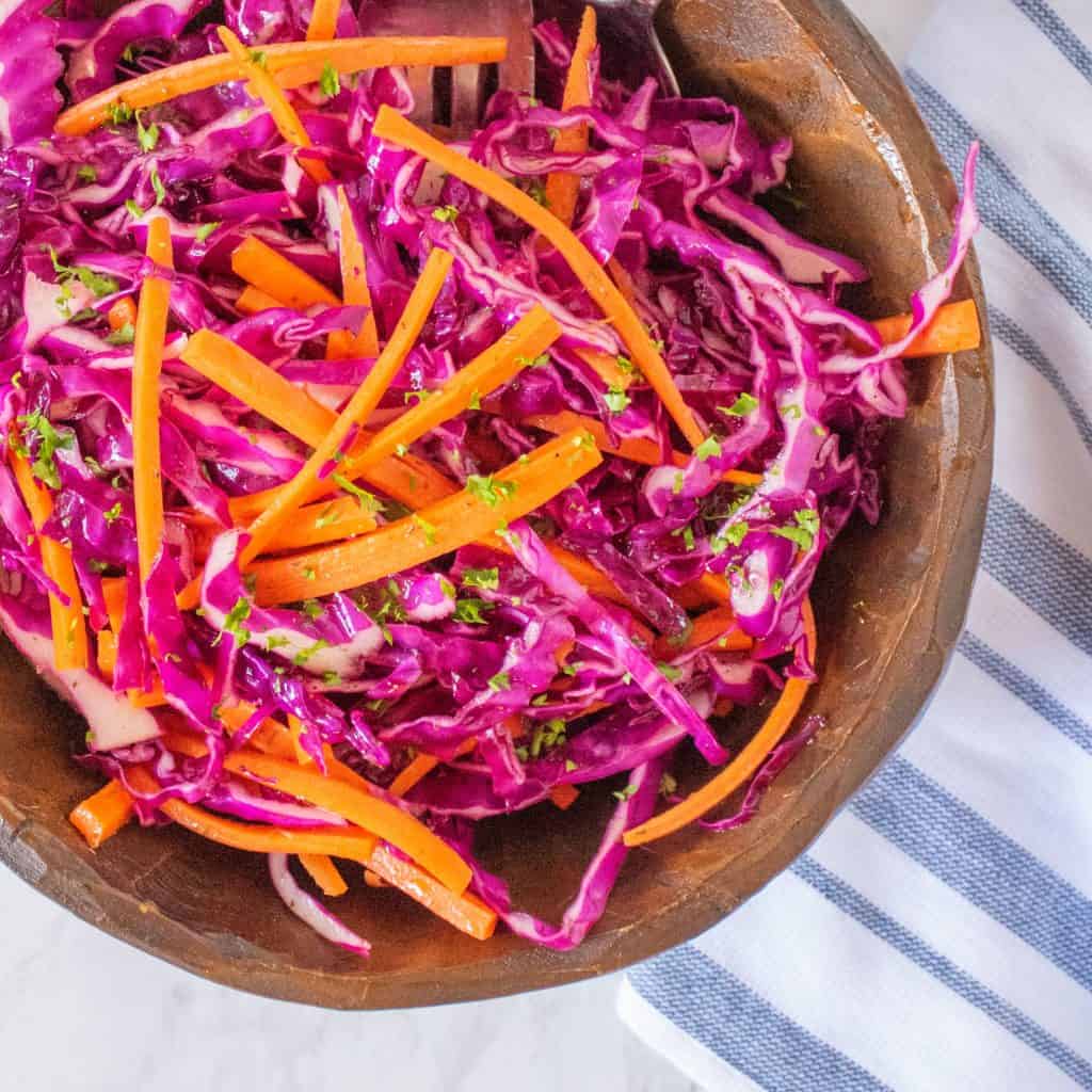 Overhead shot of wooden bowl with vinegar red cabbage coleslaw in it.