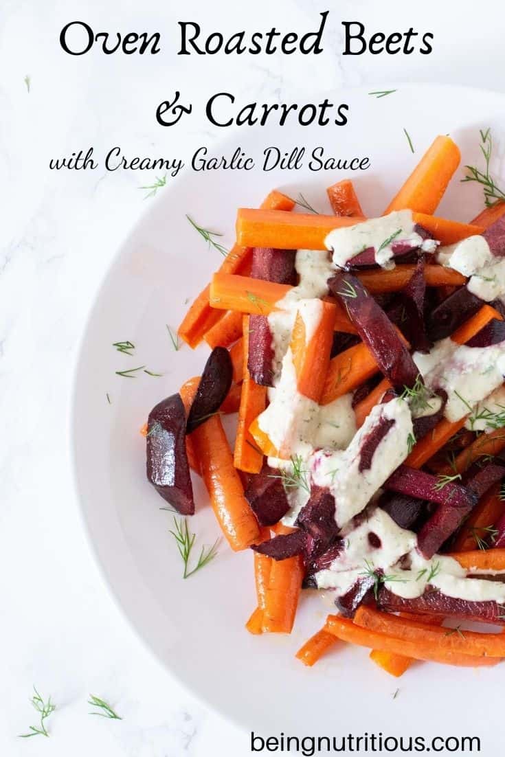 Roasted beets and carrots, cut into sticks, drizzled with garlic dill sauce on a white plate. Text overlay: Oven Roasted Beets and Carrots with Creamy Garlic Dill Sauce.