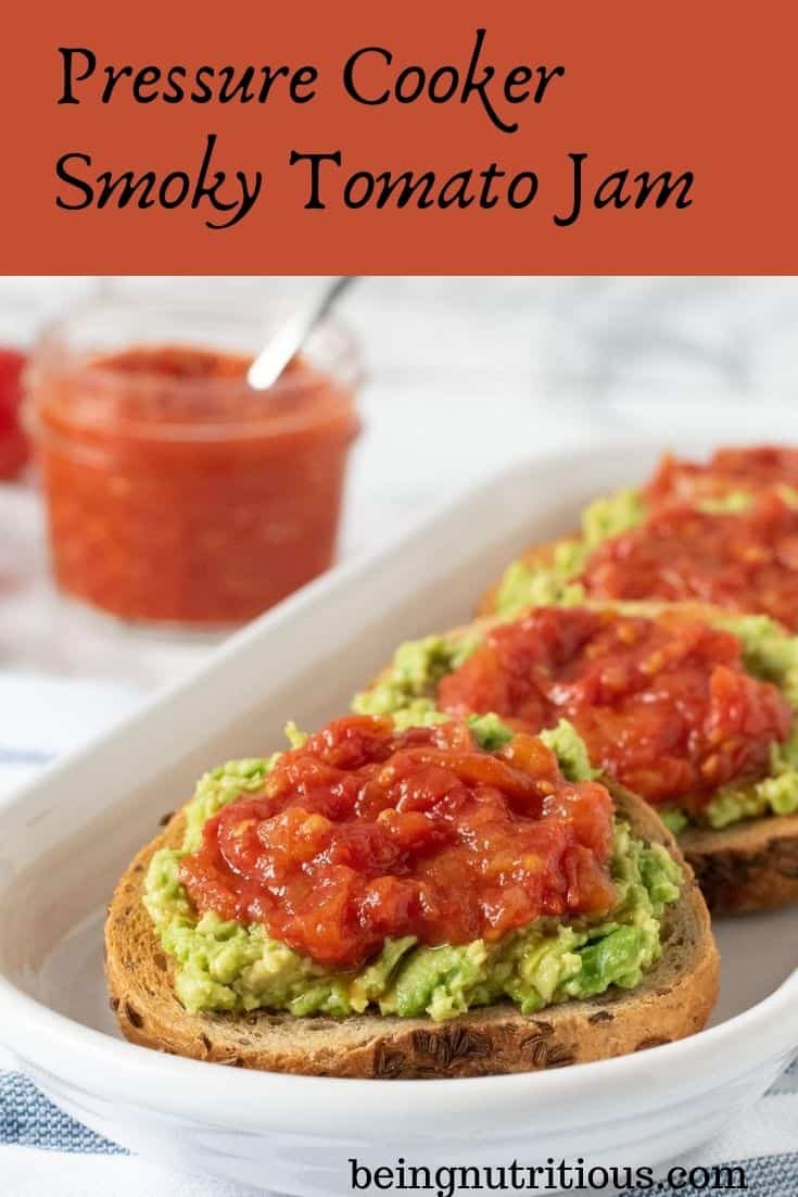 An oval, white dish, with 4 small, round slices of rye bread smeared with avocado, and topped with tomato jam. Text overlay inside a red box: Pressure Cooker Smoky Tomato Jam.