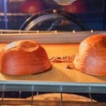 2 pie pumpkin halves face down on baking sheet after baking.