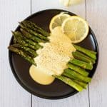 Plate of asparagus drizzled with sauce.