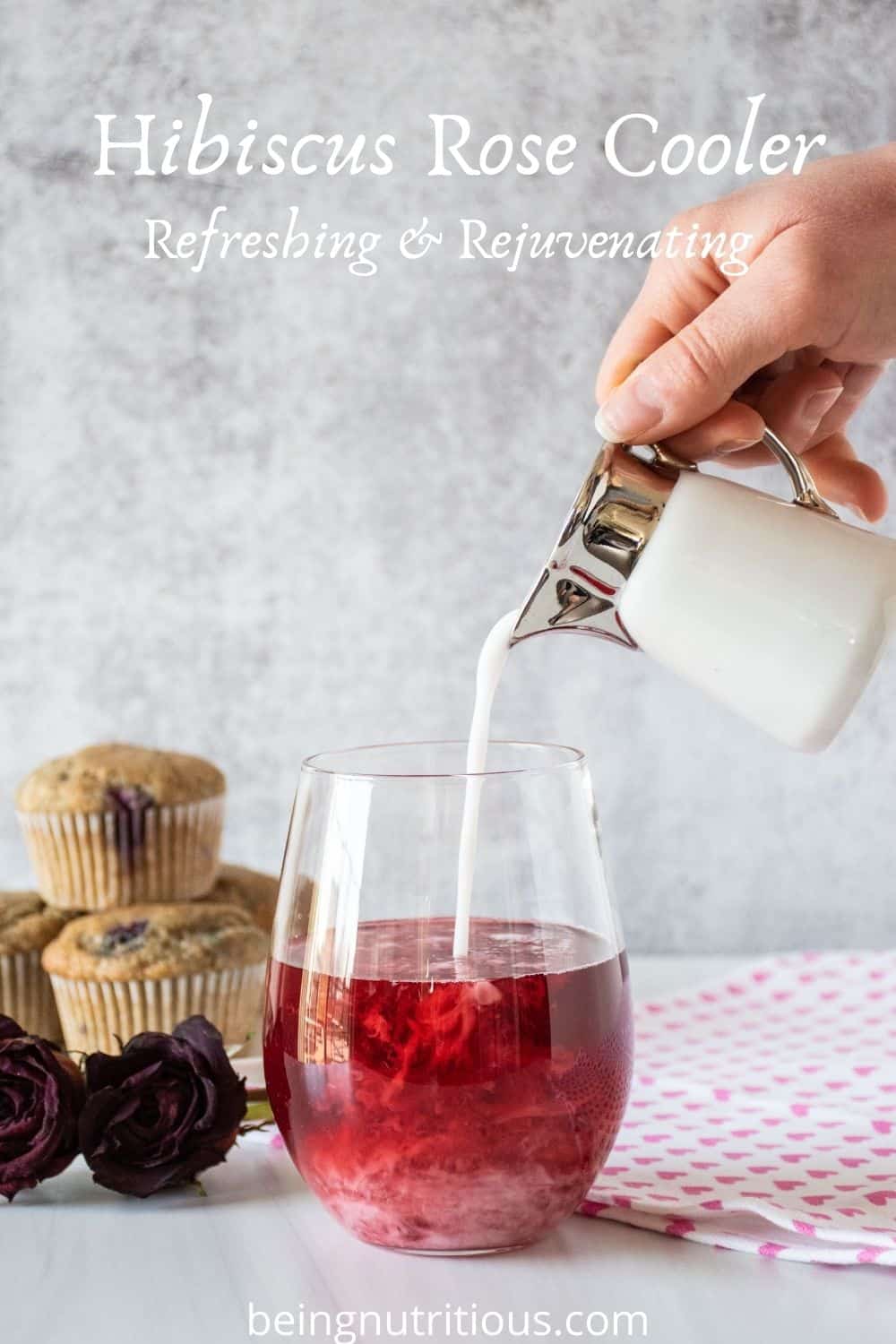 Glass of red tea with coconut milk being poured in. Text overlay: Hibiscus Rose Cooler; Refreshing & Rejuvenating.