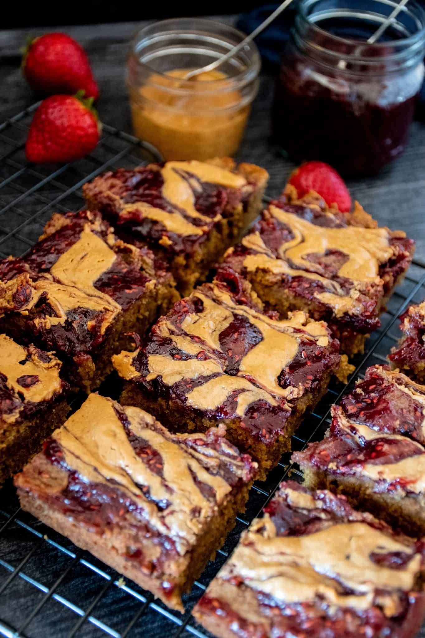 Dessert bars with peanut butter and jelly on a wire rack.