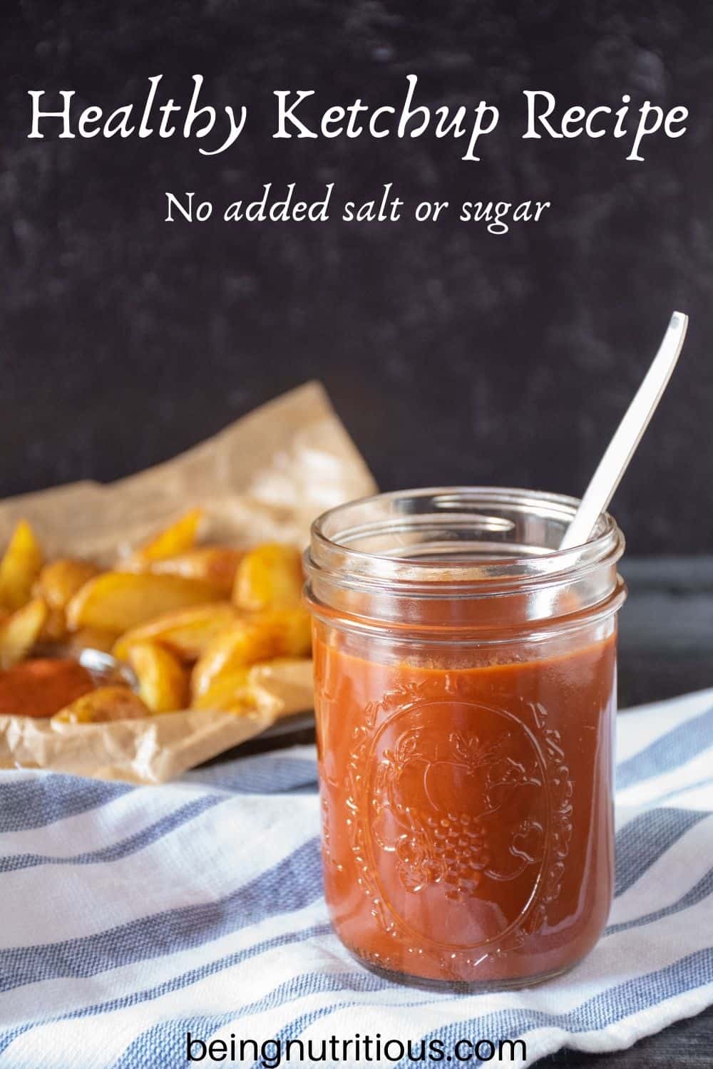 Jar of ketchup, with basket of potato wedges behind. Text overlay: Healthy Ketchup Recipe; no added salt or sugar.