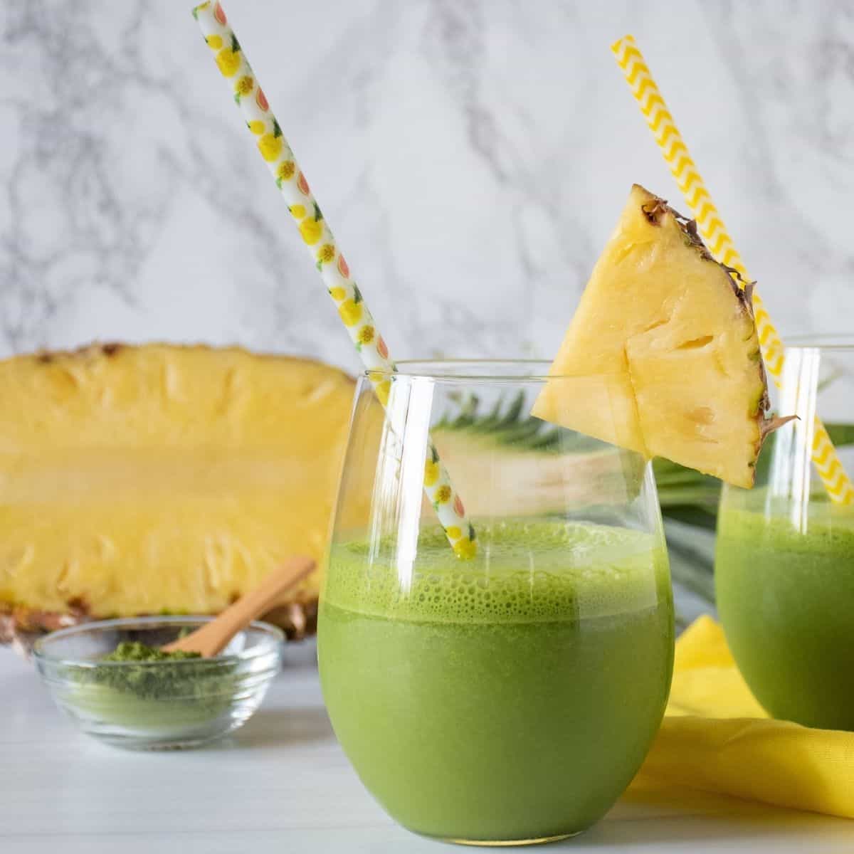 Glass of iced matcha drink, garnished with a pineapple slice.