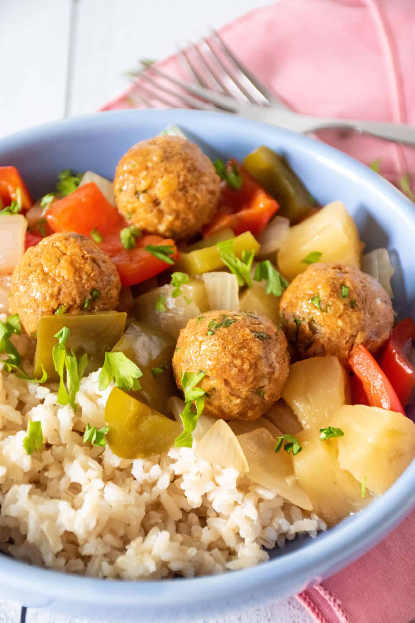 Bowl with rice, chickpea meatballs, and onions and bell peppers.