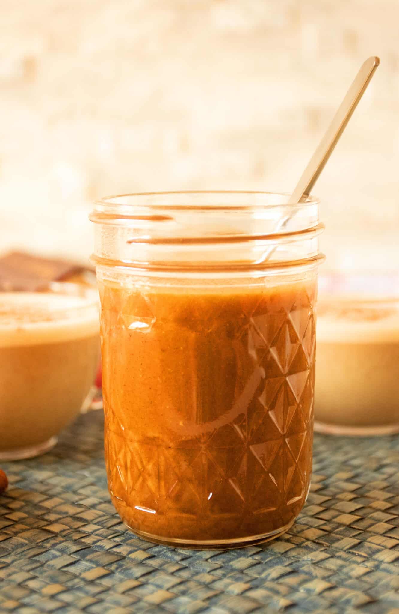 Glass jar with pumpkin spice syrup in it.