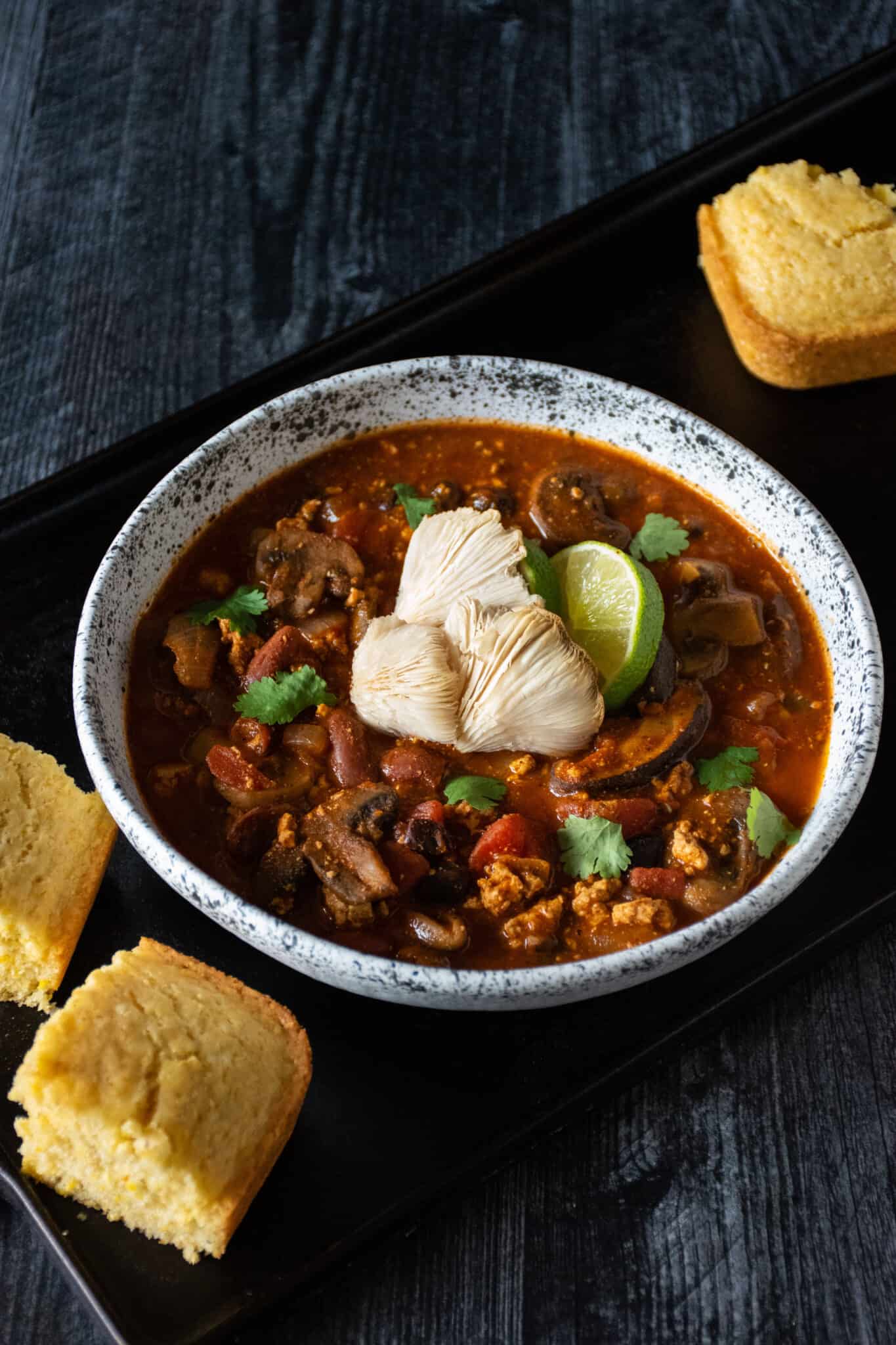 Bowl of chili with squares of cornbread surrounding.