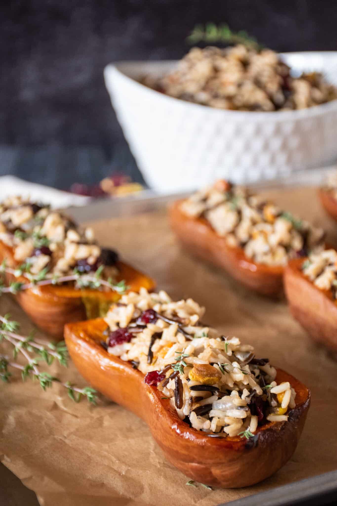 Stuffed honeynut squash halves on a baking pan.