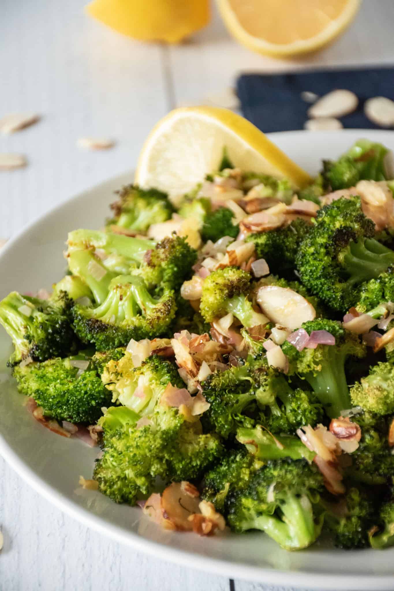 Plate of roasted broccoli with almond topping.