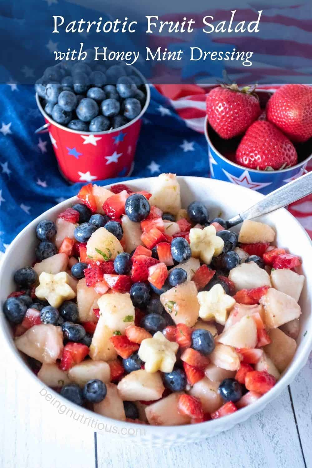 Bowl of red white and blue fruit salad. Text overlay: Patriotic Fruit Salad with Honey Mint Dressing.