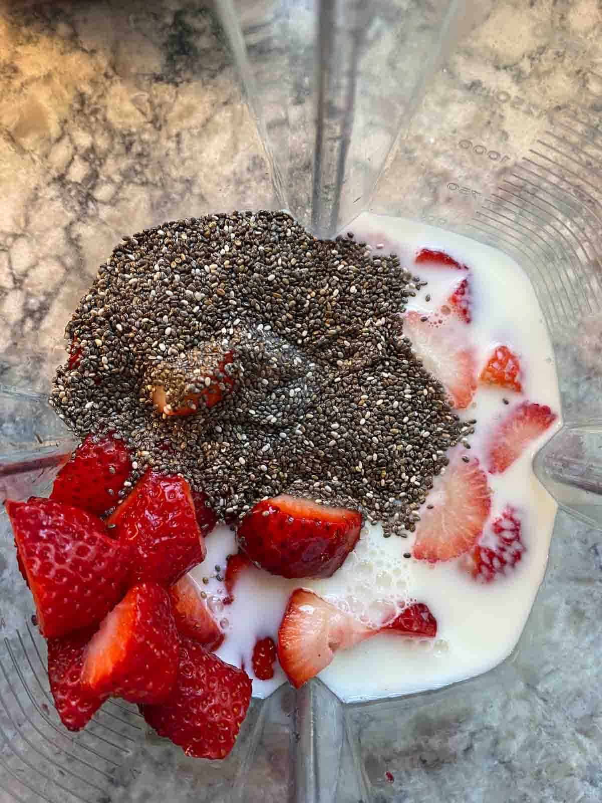 Blender with strawberry pudding ingredients in it.