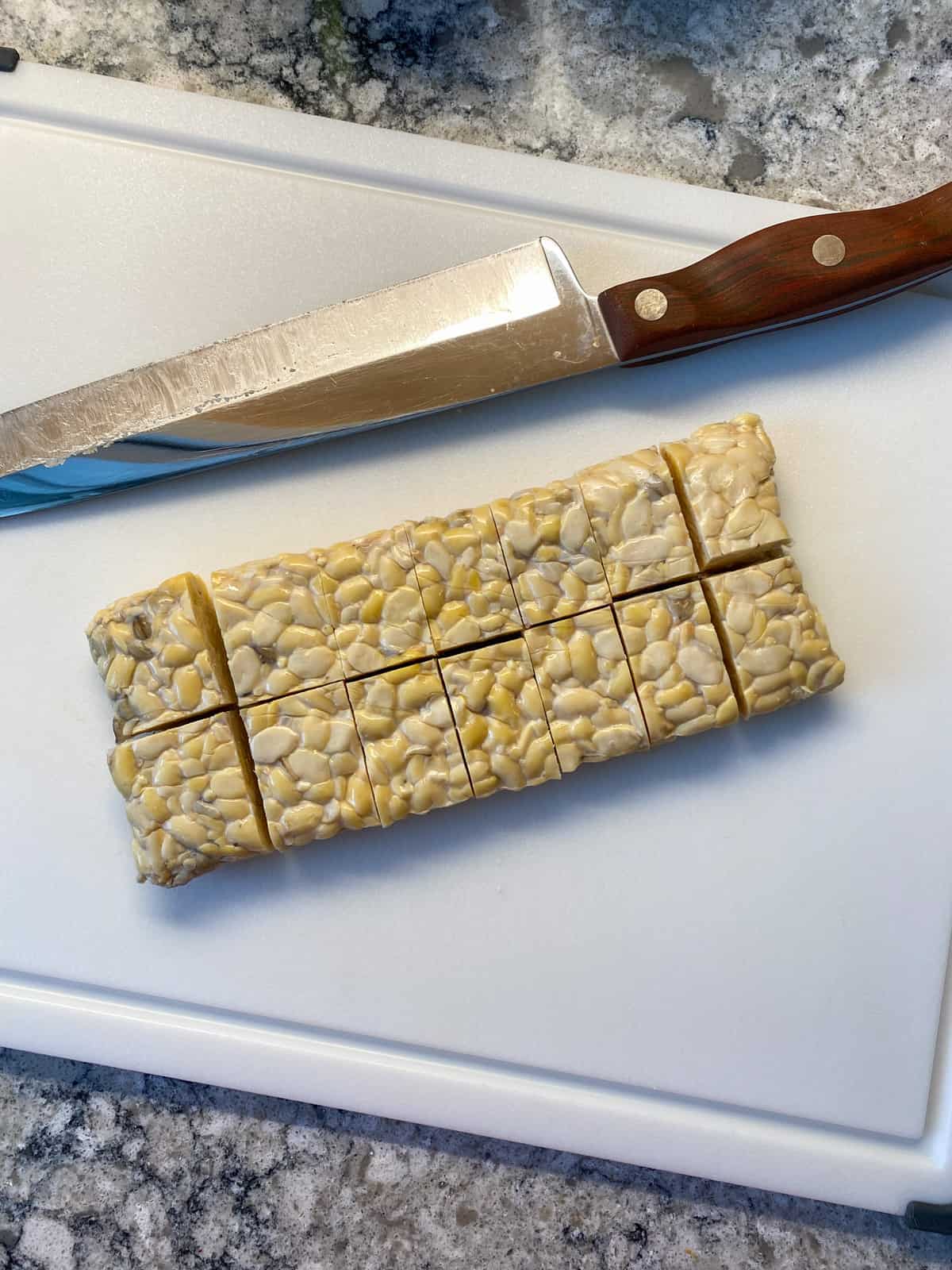 A block of tempeh cut into 14 pieces.