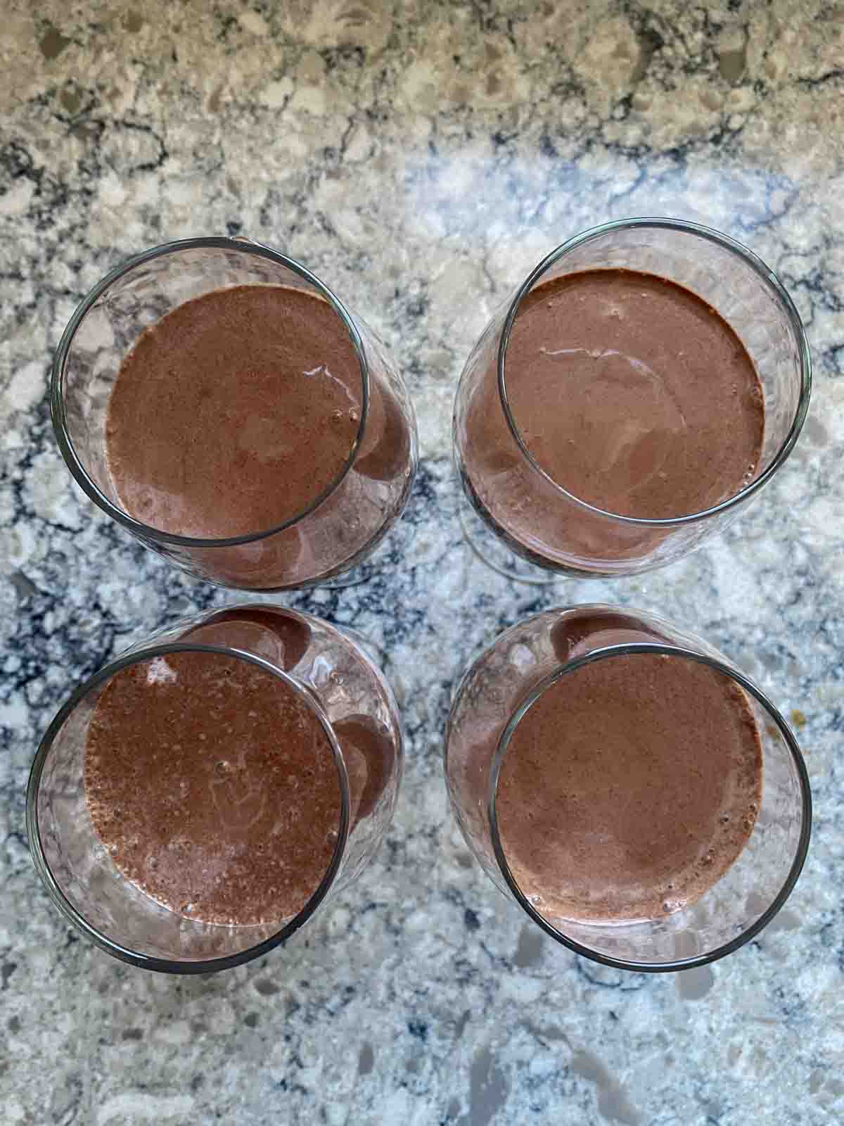 Overhead shot of chocolate pudding - topping strawberry pudding - in dessert glasses.