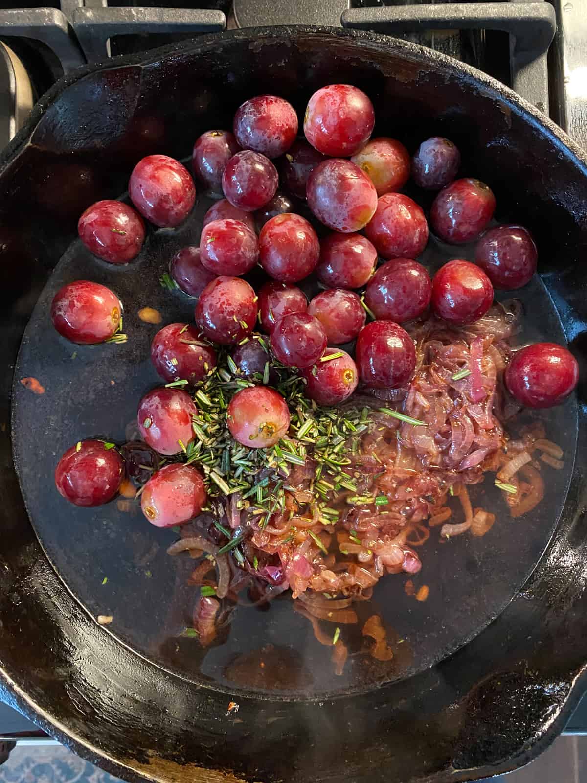 Simmering grapes, caramelized onions, and rosemary in cooking wine and vegetable broth.