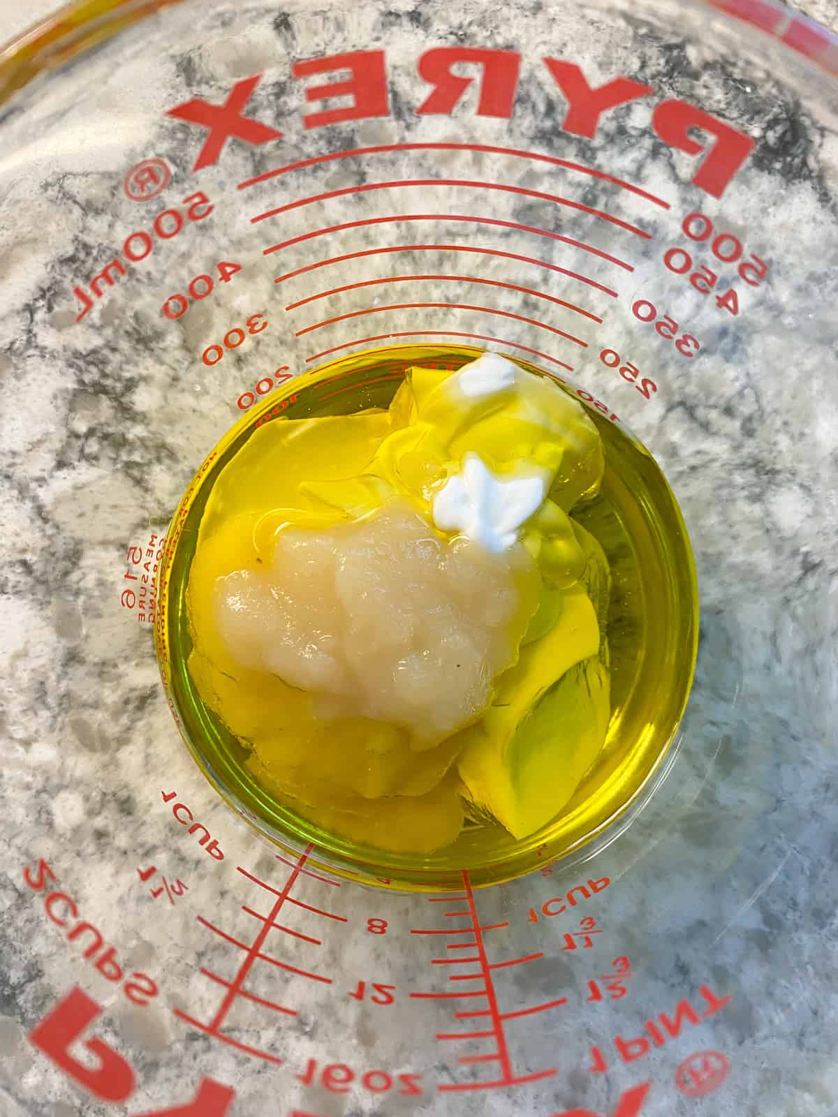 Wet ingredients in a glass liquid measuring cup.