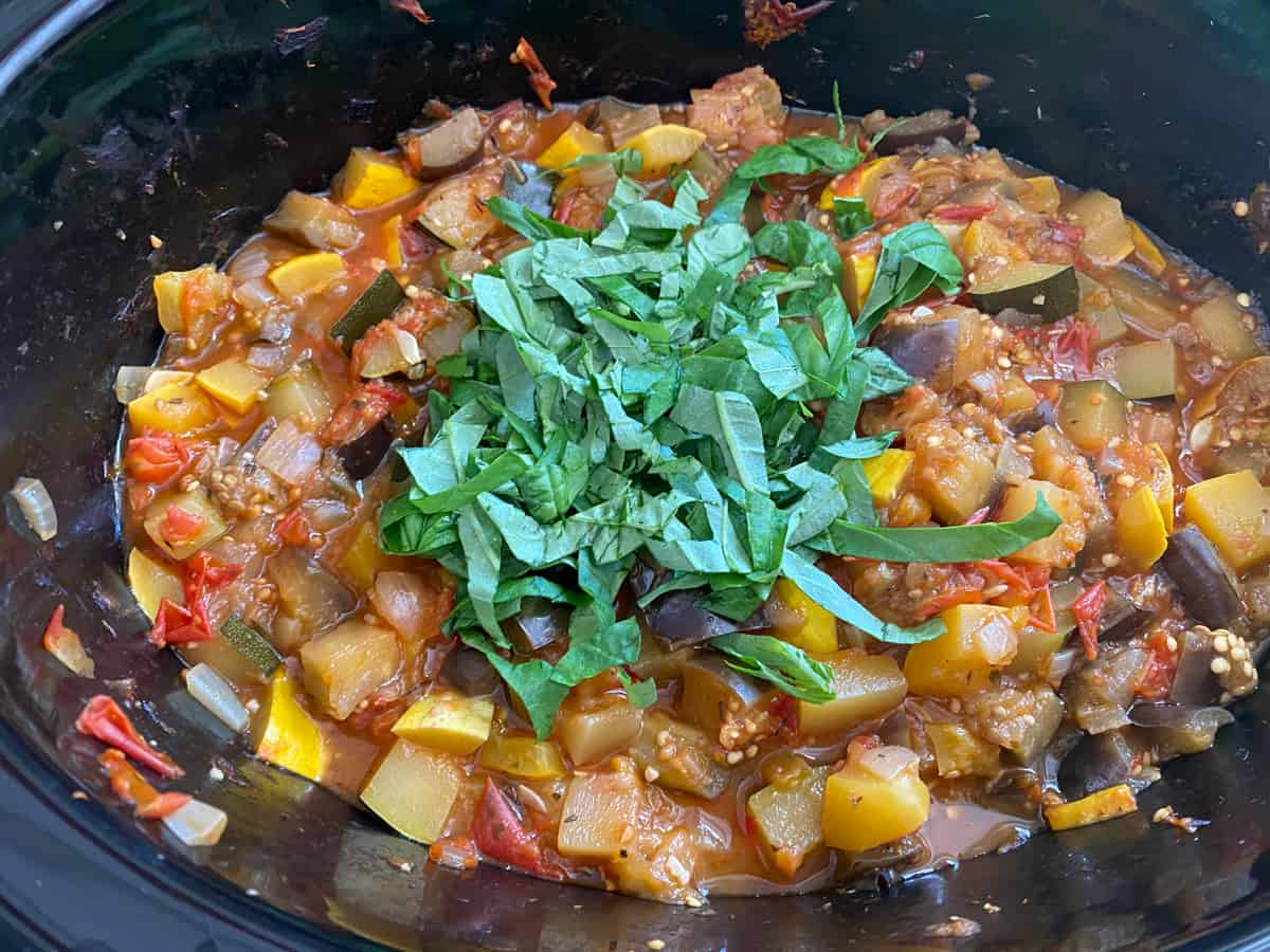 Finished ratatouille, in the crock pot, with basil chiffonade on top.