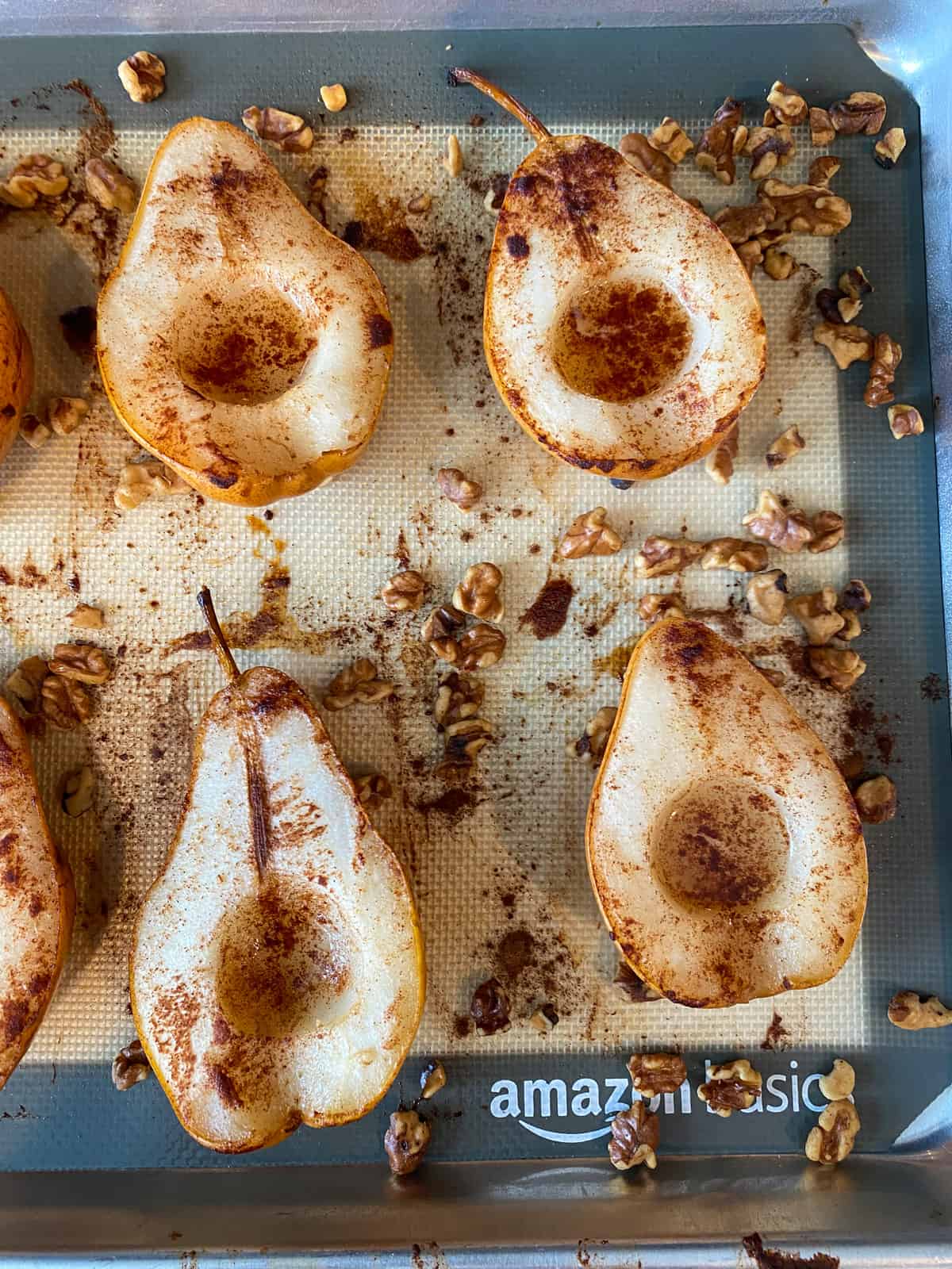 Pears finished baking, on a baking sheet.