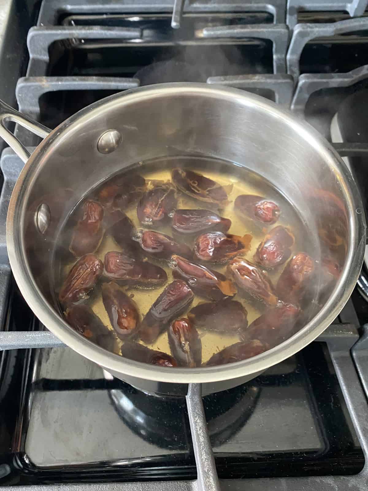 Whole dates simmering in water to soften.