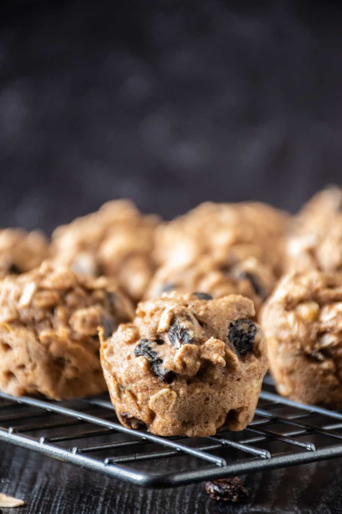 Close up of a mini muffin on a cooling rack with the rest of the muffins in the background.