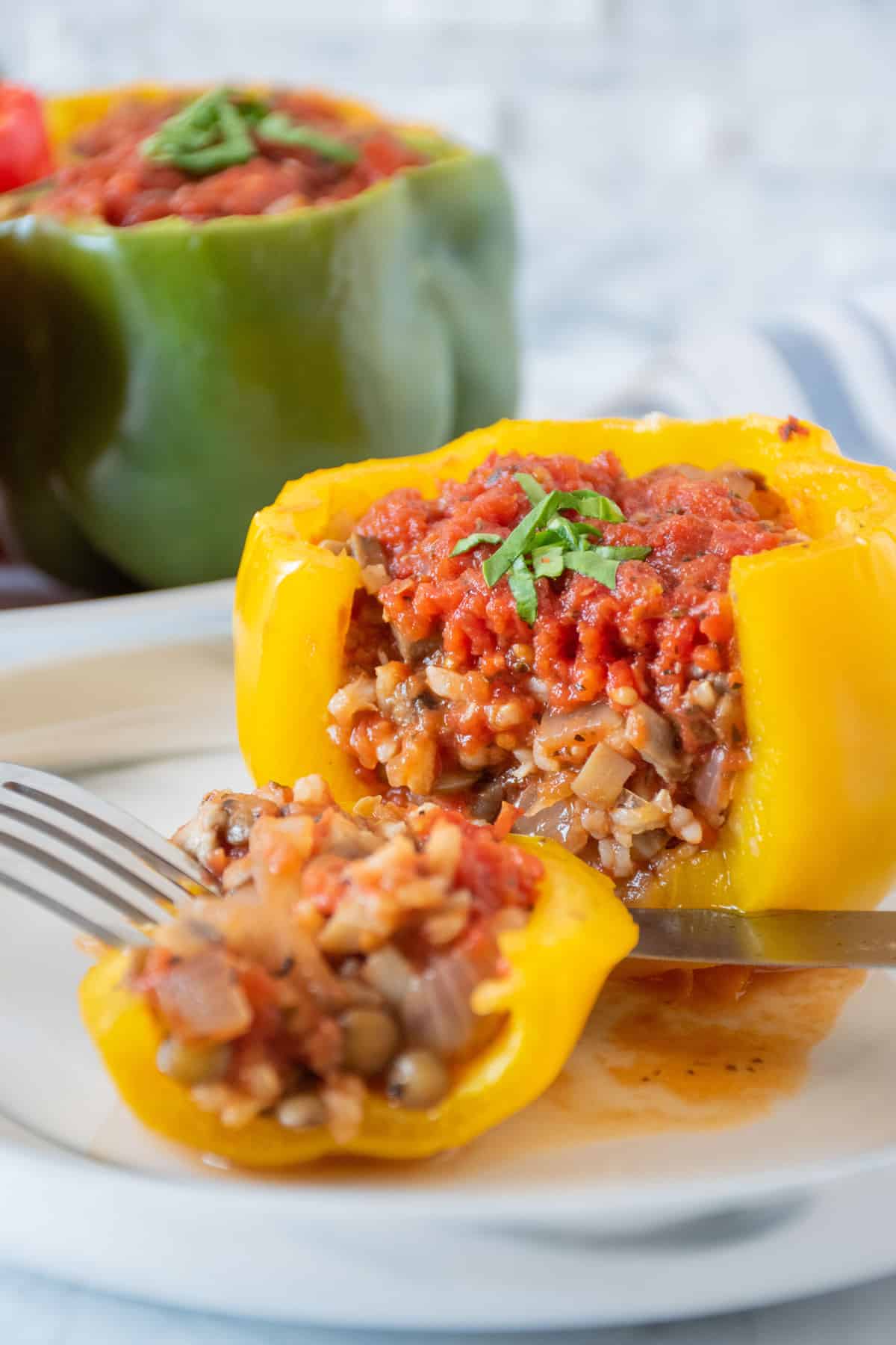 A stuffed yellow bell pepper, with a slice removed, to see the filling inside.