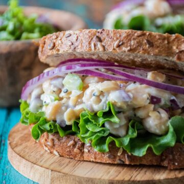 Chickpea salad on a sandwich, with lettuce and red onion.