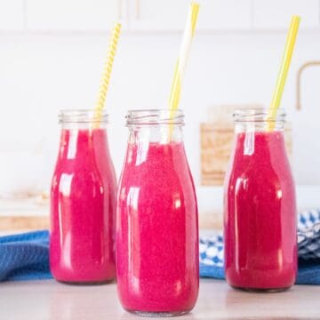 Three small jars of smoothie, with straws.