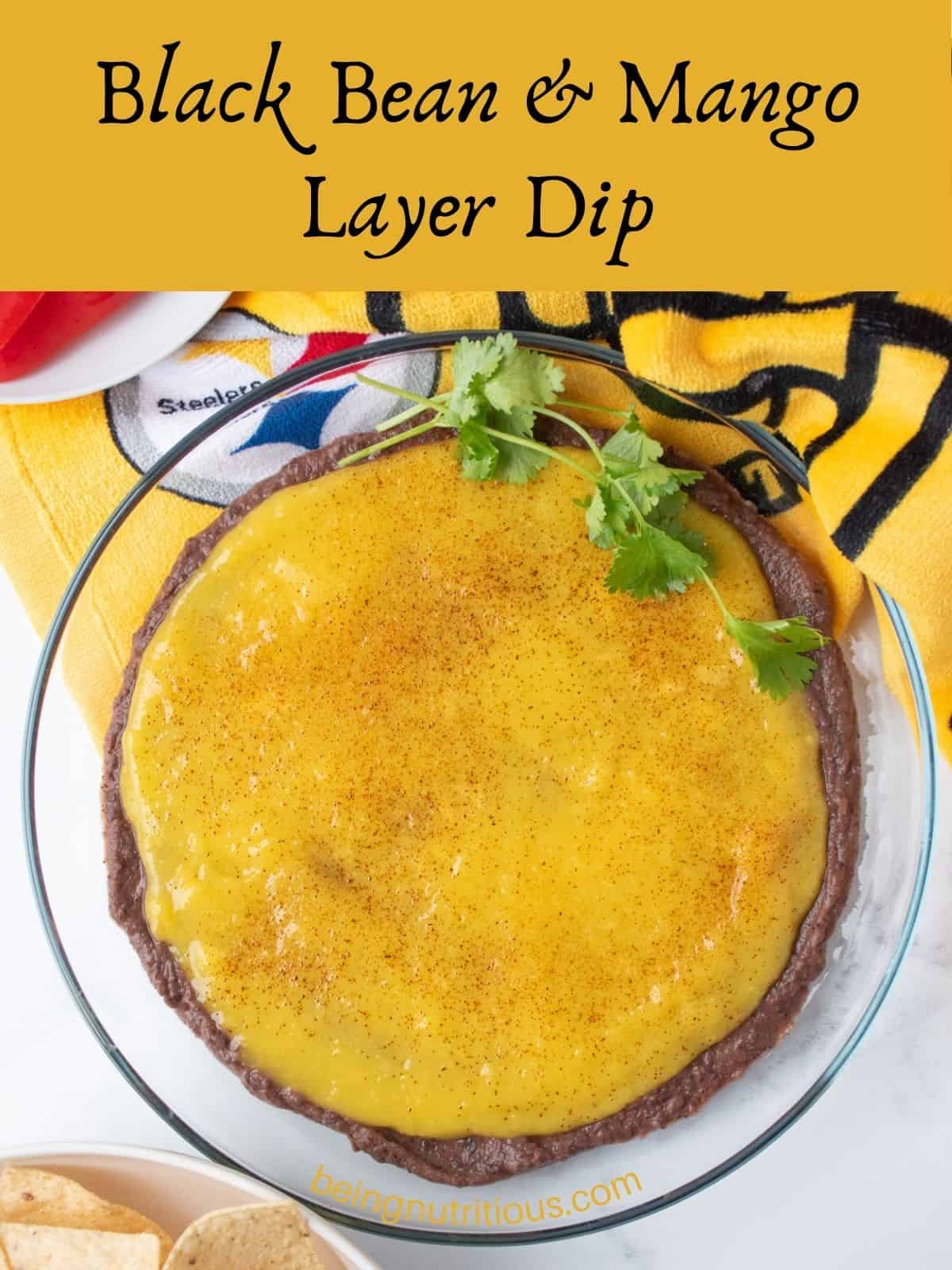 Dish with black bean dip and mango puree layered, garnished with fresh cilantro. Text overlay: Black Bean and Mango Layer Dip.