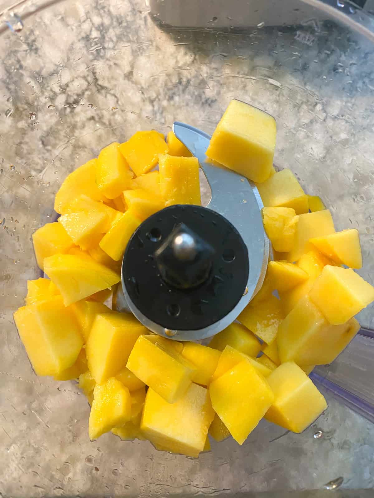 Mango chunks in a food processor.
