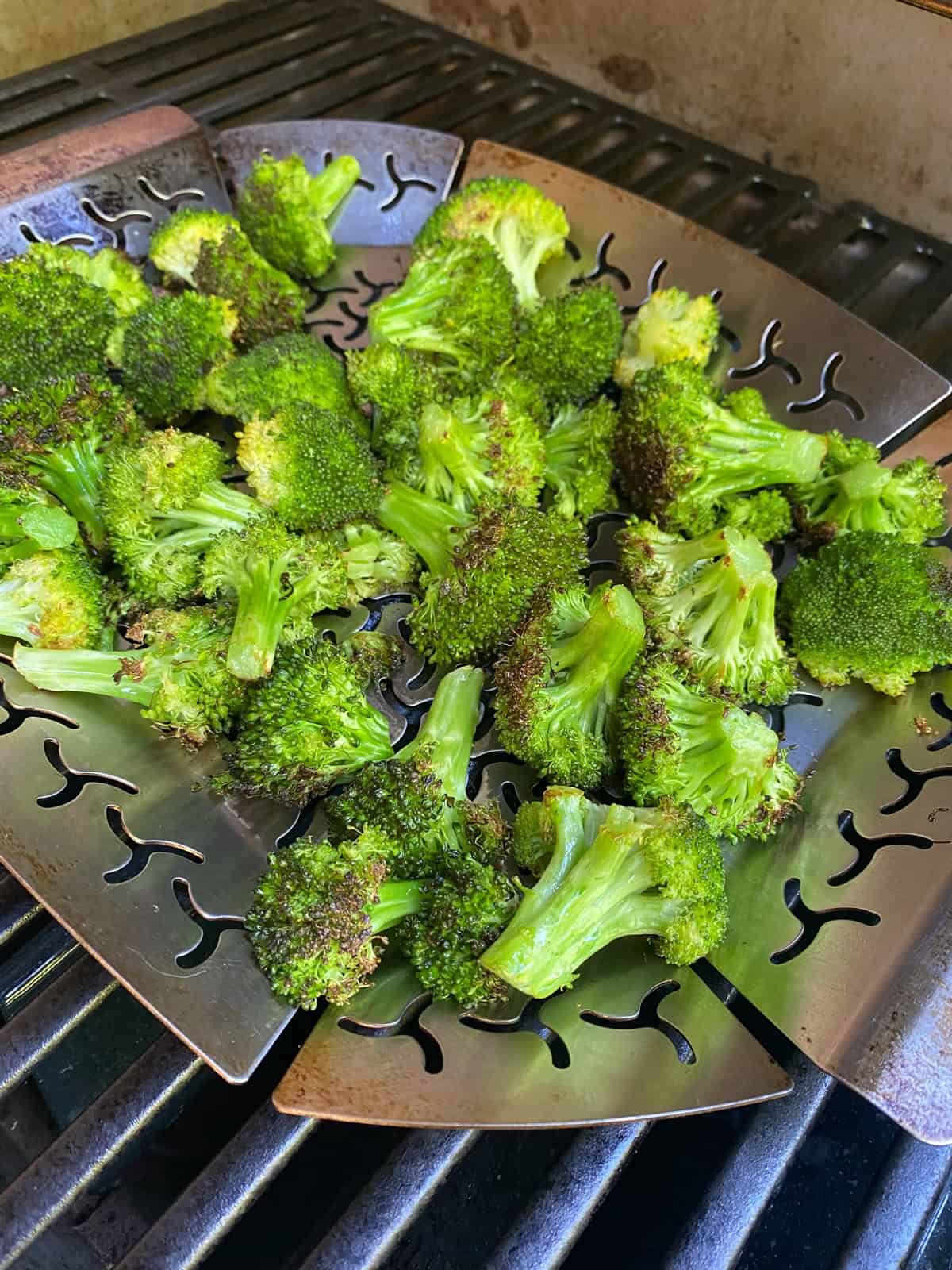 Grilled broccoli florets on a grill pan, on the grill.