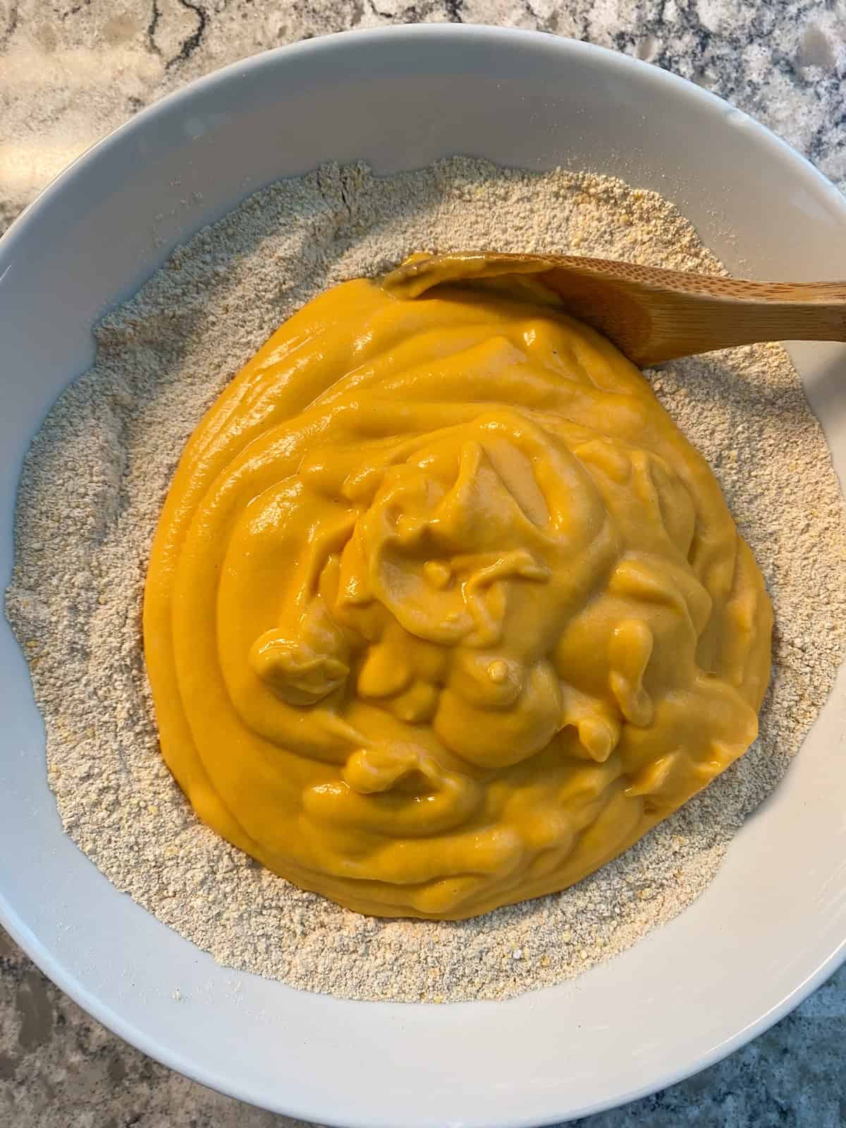 Dry ingredients with wet ingredients poured into the bowl.