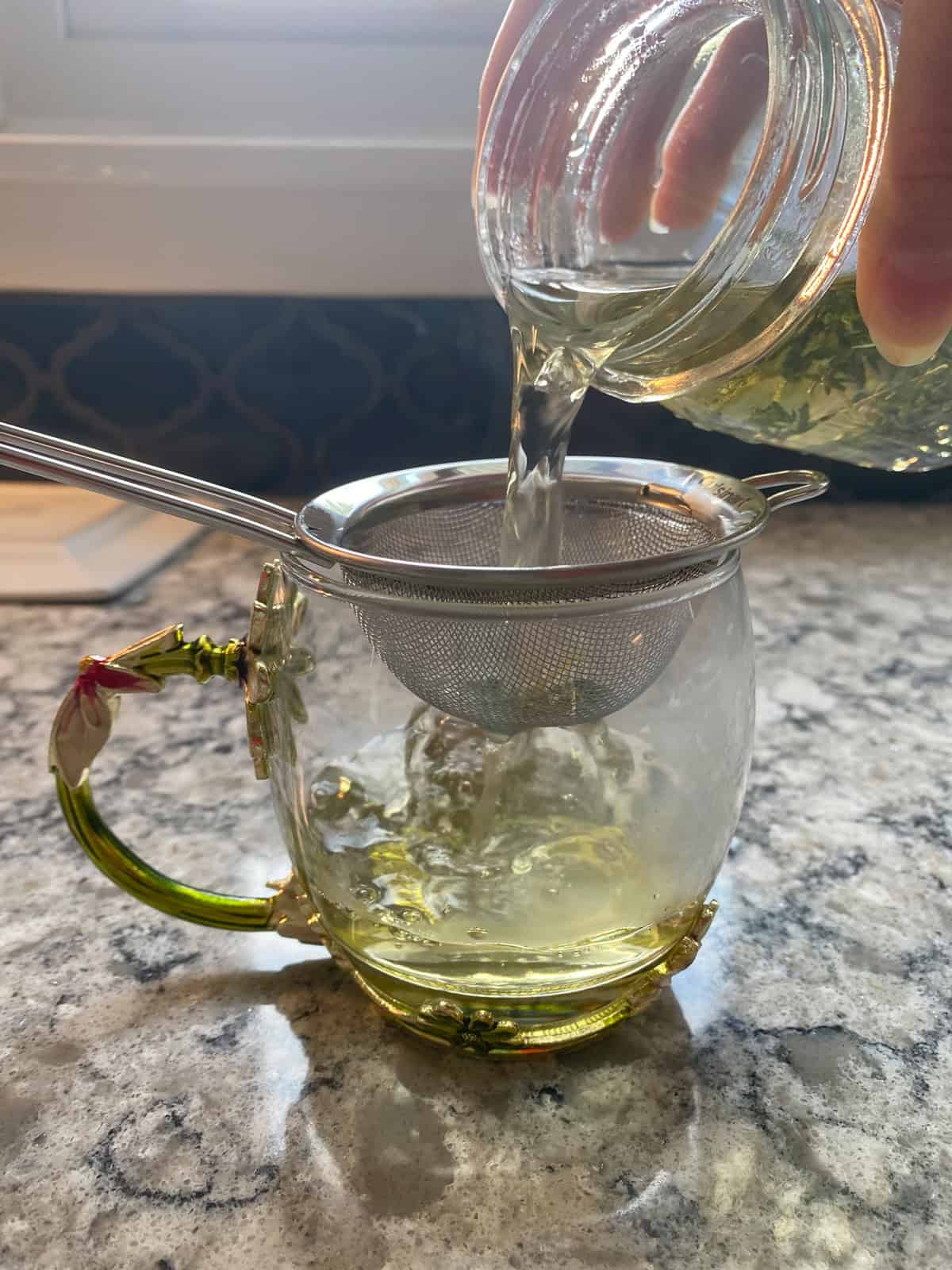 Straining the tea into a cup.