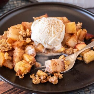 Pear apple crisp on a dish, with a scoop of vanilla ice cream.