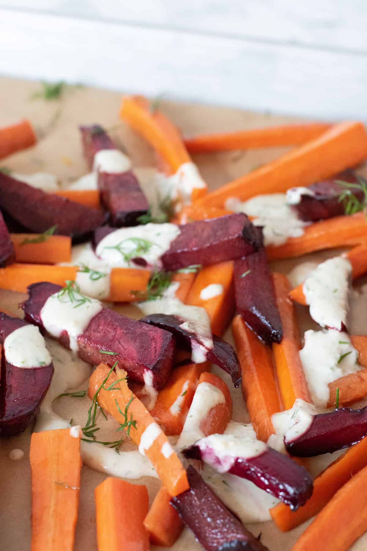Roasted beets and carrots, cut into large matchsticks, drizzled with a white sauce and sprinkled with chopped dill.