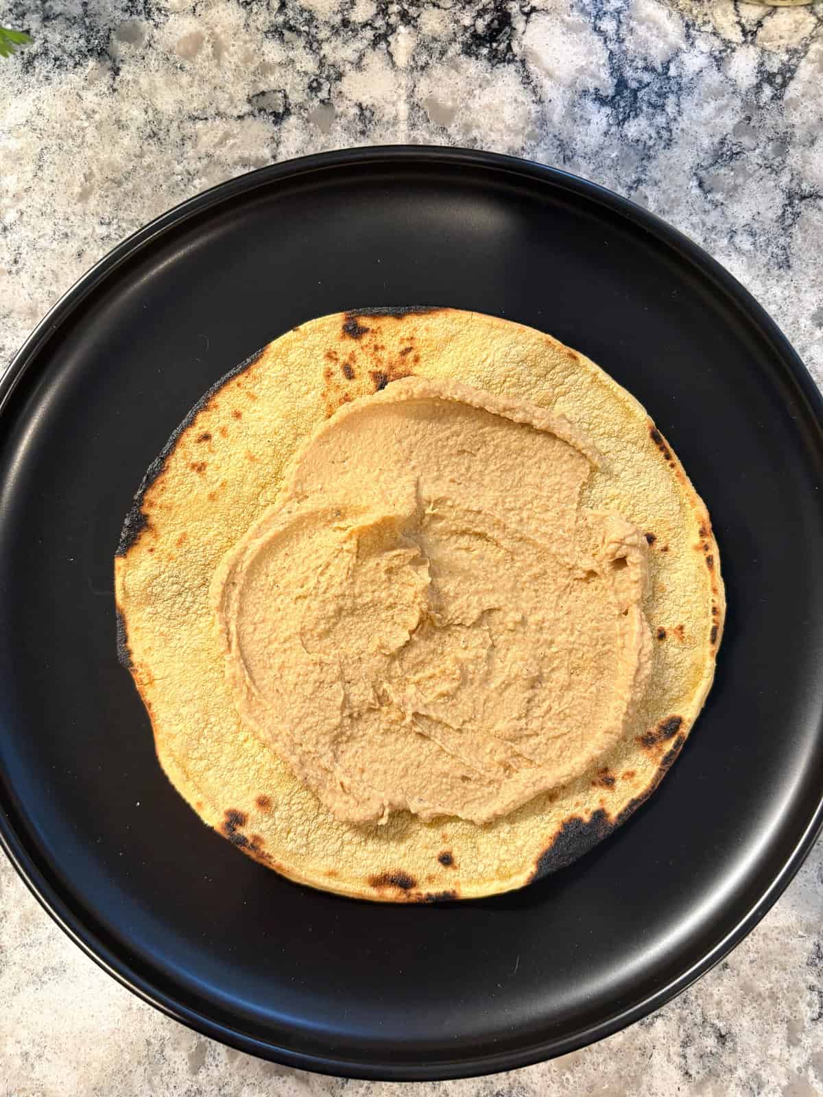 Tortilla smeared with hummus.