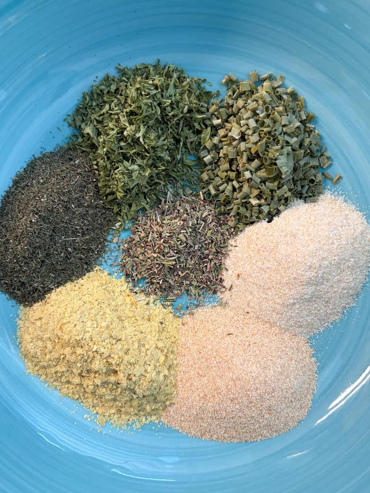 Ingredients for ranch seasoning in small individual piles in a bowl.