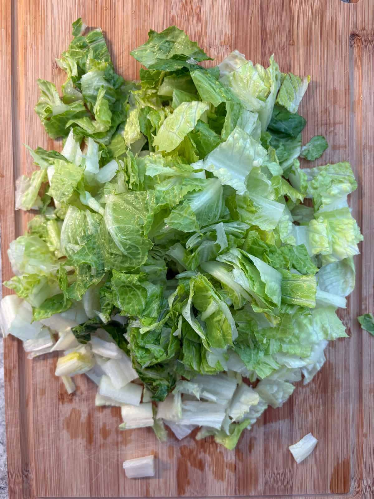 Chopped romaine lettuce on a cutting board.