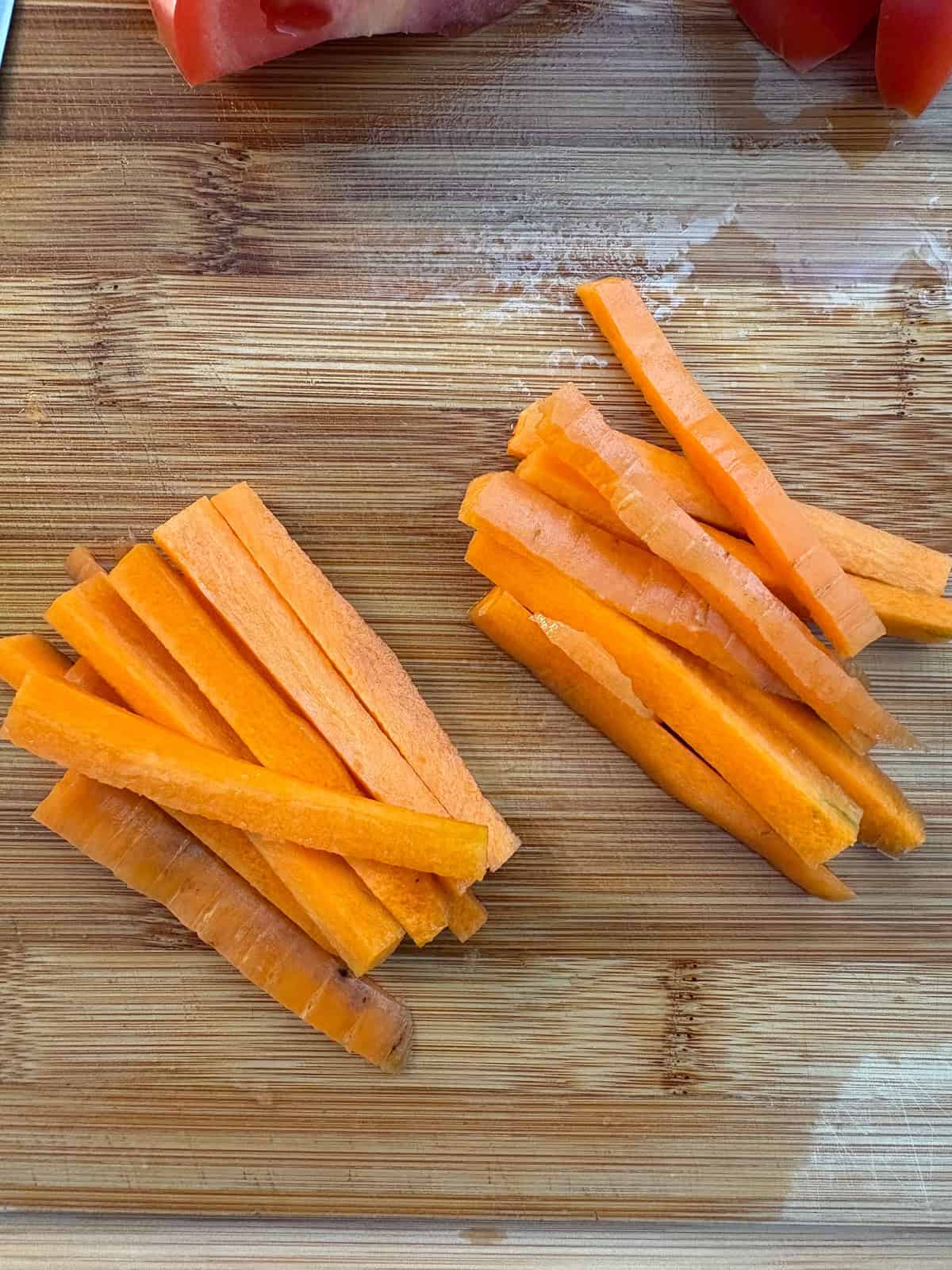 Julienne cut carrots on a cutting board.
