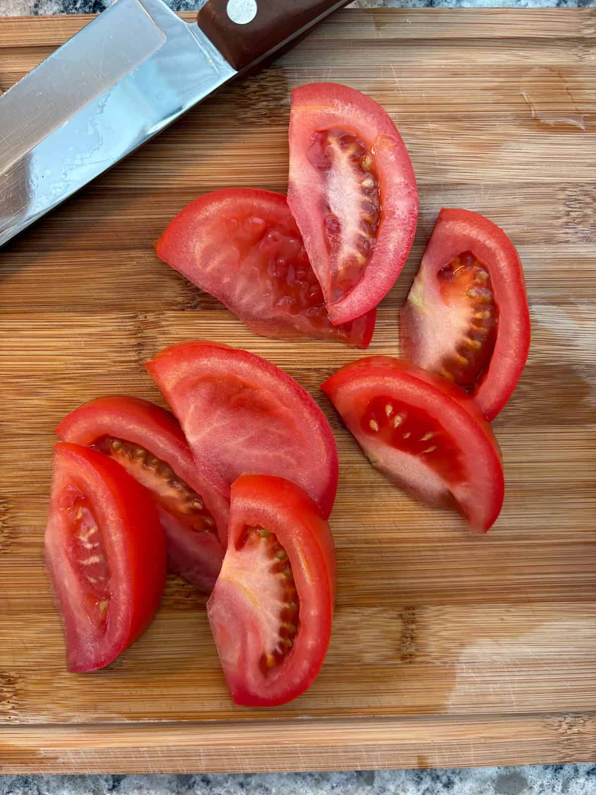 Sliced tomatoes on a cutting board.